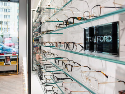 Ekspozycja okularów korekcyjnych na szklanych półkach w salonie Arts Optyk.