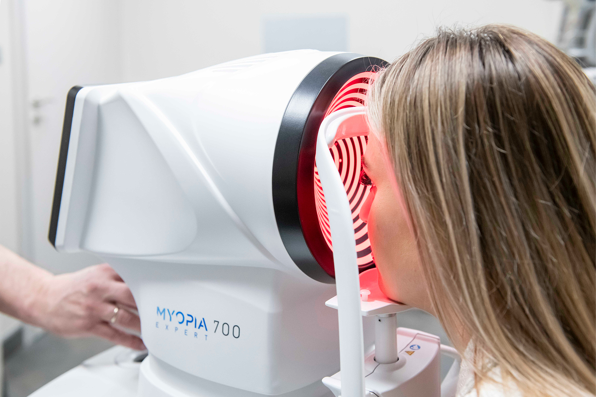 Blondynka podczas badania wzroku na profesjonalnym urządzeniu.